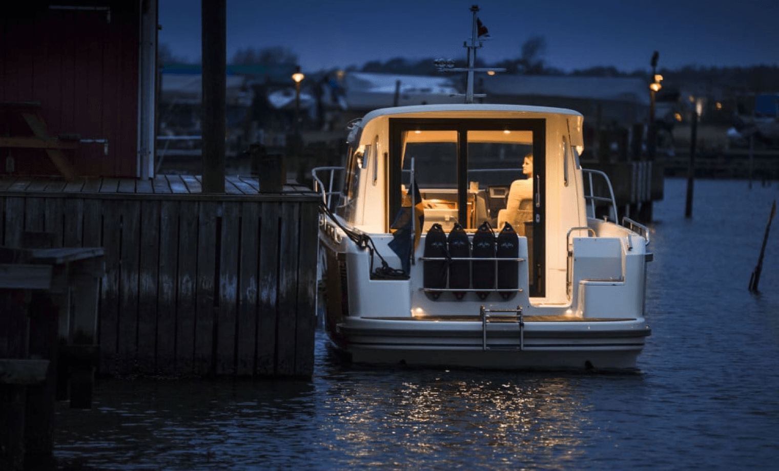 The back of a boat in the harbour at night