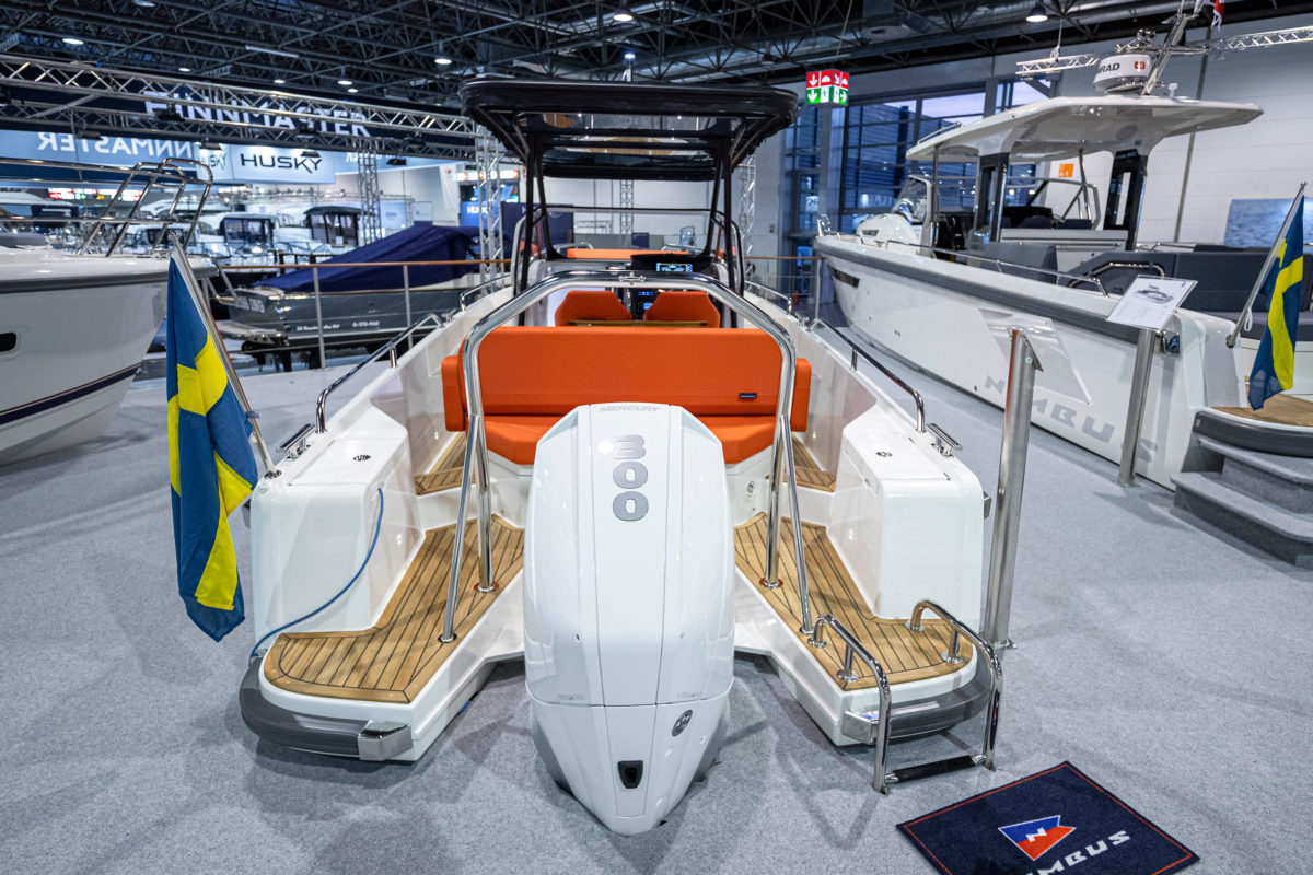 The back of a boat in a showroom with orange seats