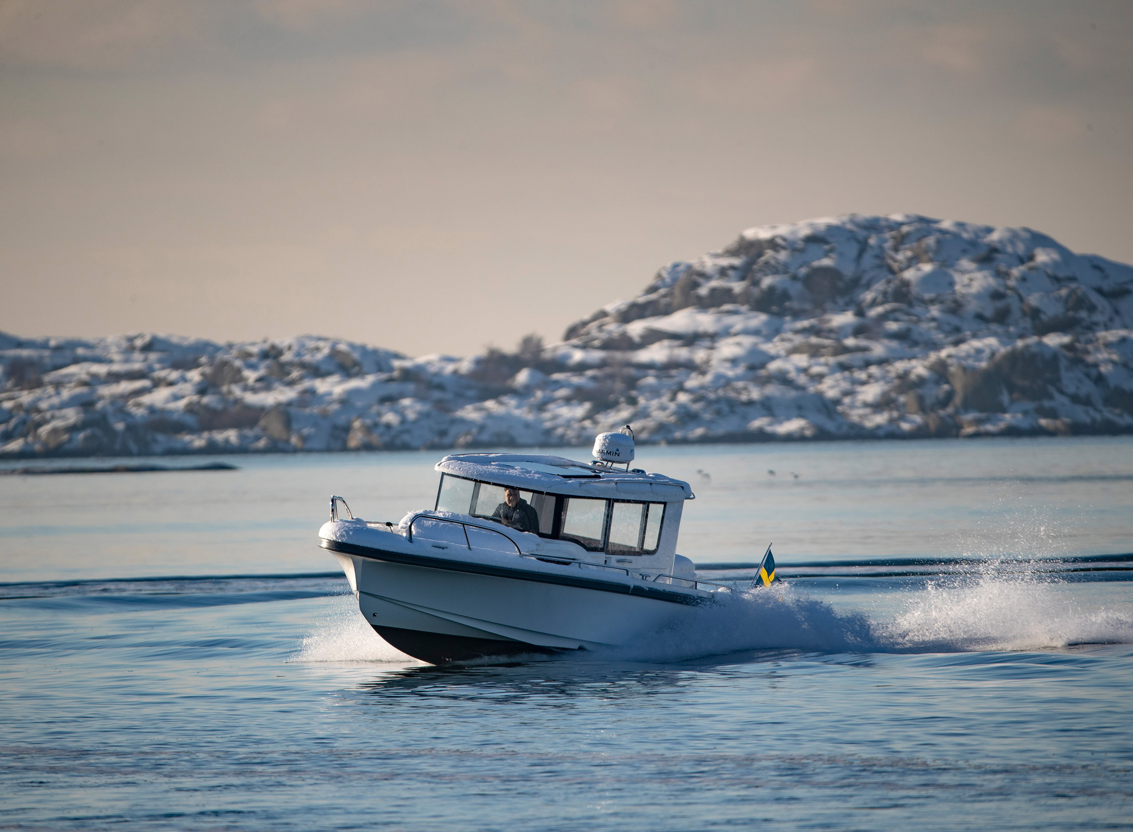 Nimbus C9 boat driving in the ocean on a snowy day